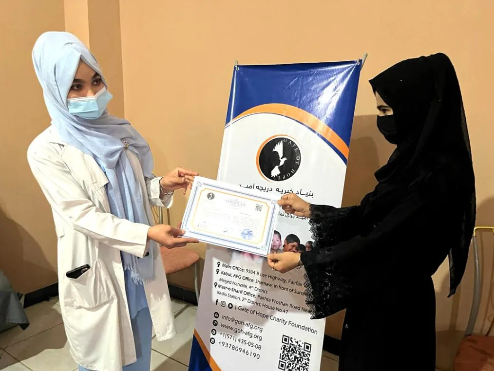 Afghan woman receiving a certificate at a Gate of Hope women empowerment event in Afghanistan